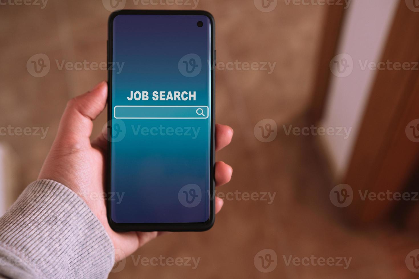 mujer utilizando teléfono inteligente a encontrar un trabajo. encontrar tu carrera profesional. en línea sitio web en pantalla a buscar un trabajo. foto