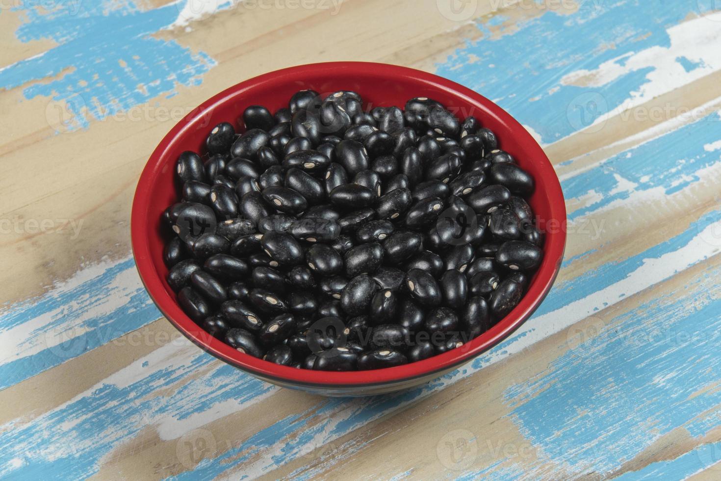 bowl with black bean beans on blue rustic wooden table, top view photo