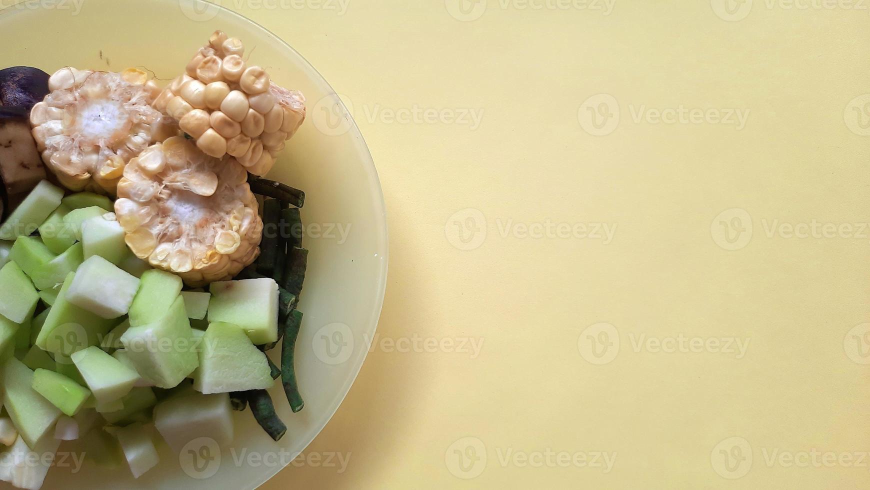 ingredients for traditional Sundanese cooking, sayur asem with yellow background photo