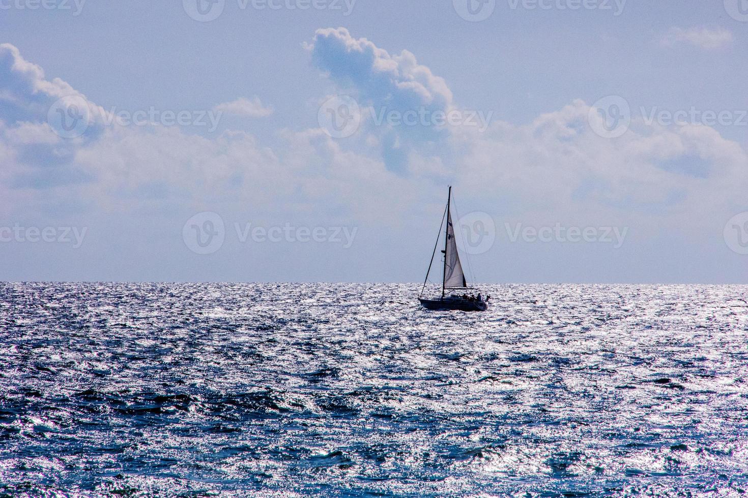 calm blue seaside landscape with water and sky and sailboats photo