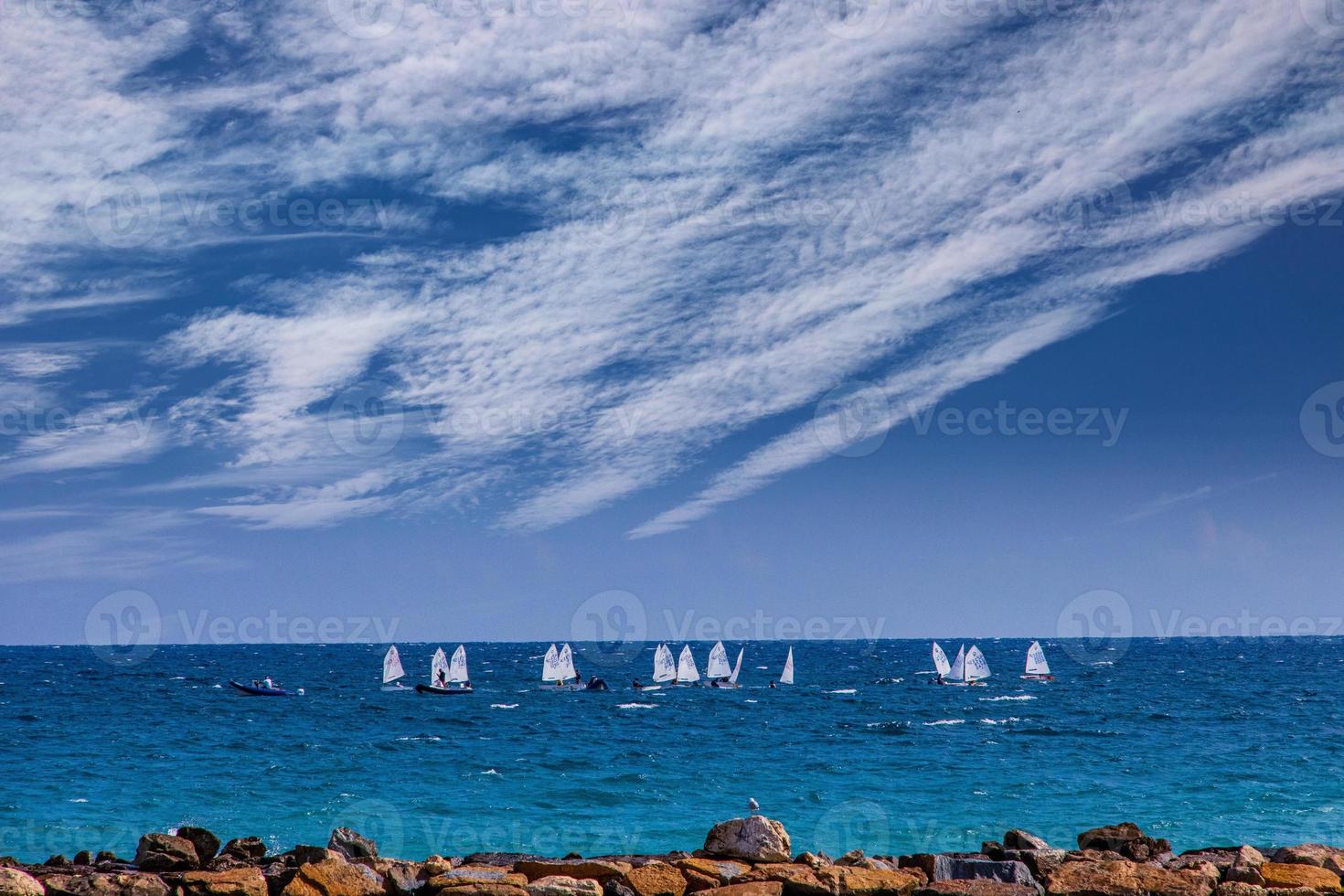 calm blue seaside landscape with water and sky and sailboats photo