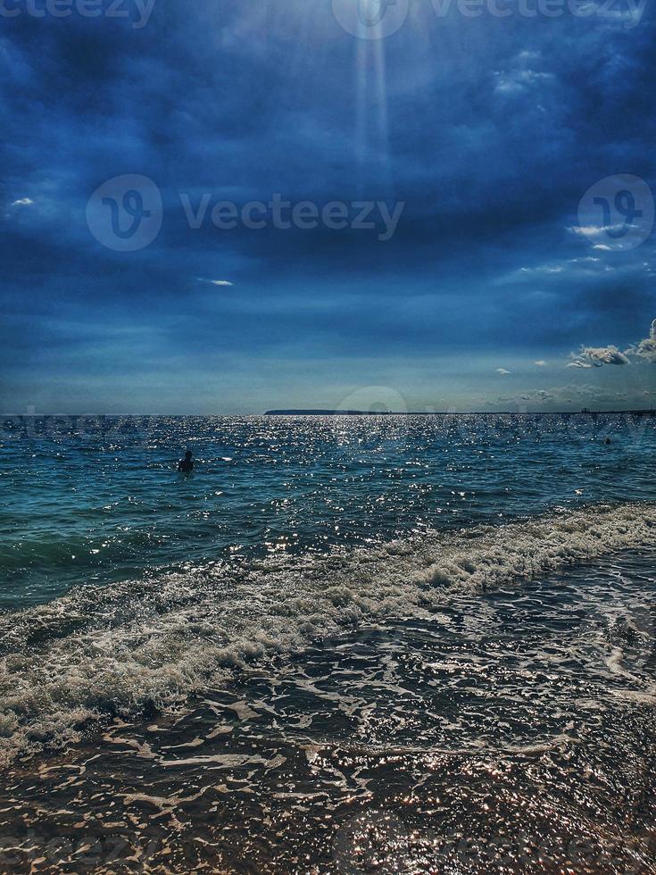 calm blue seaside landscape with water and sky and sailboats photo