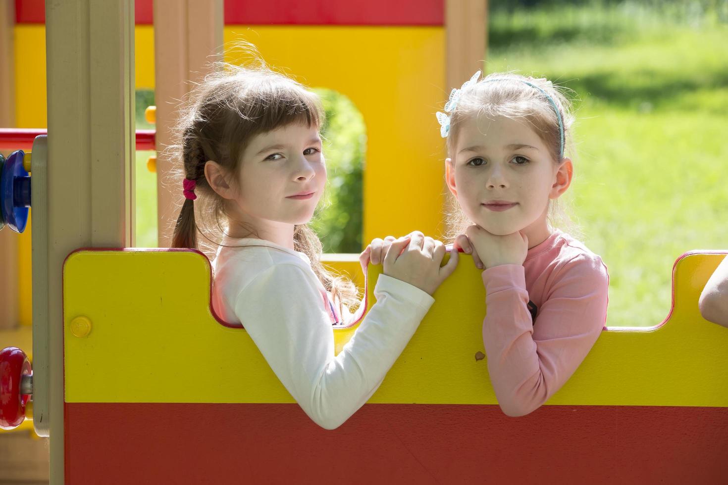Two little girlfriends are playing. Kindergarten girls at the playground photo