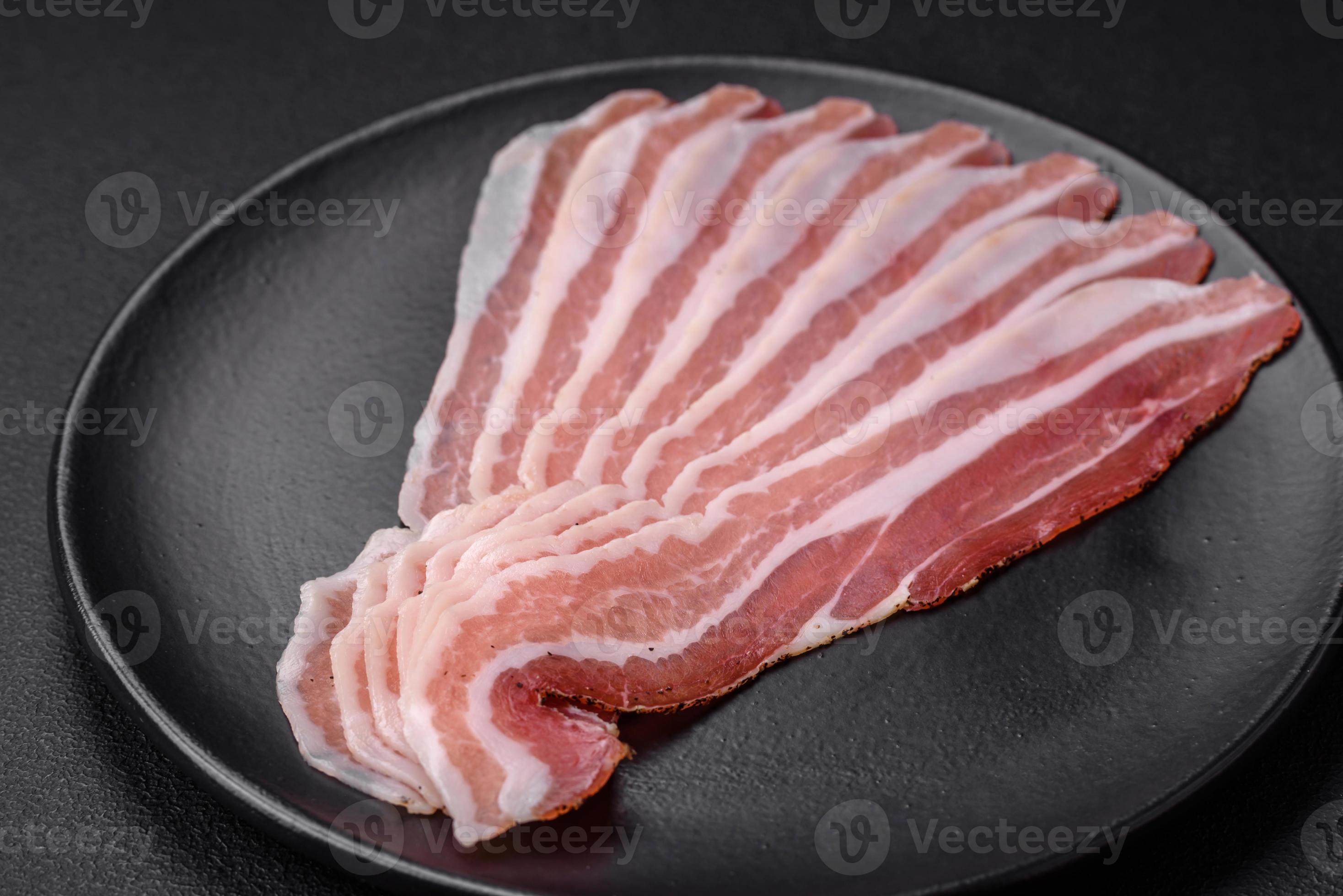 Delicious fresh pancetta with salt and spices cut into thin slices