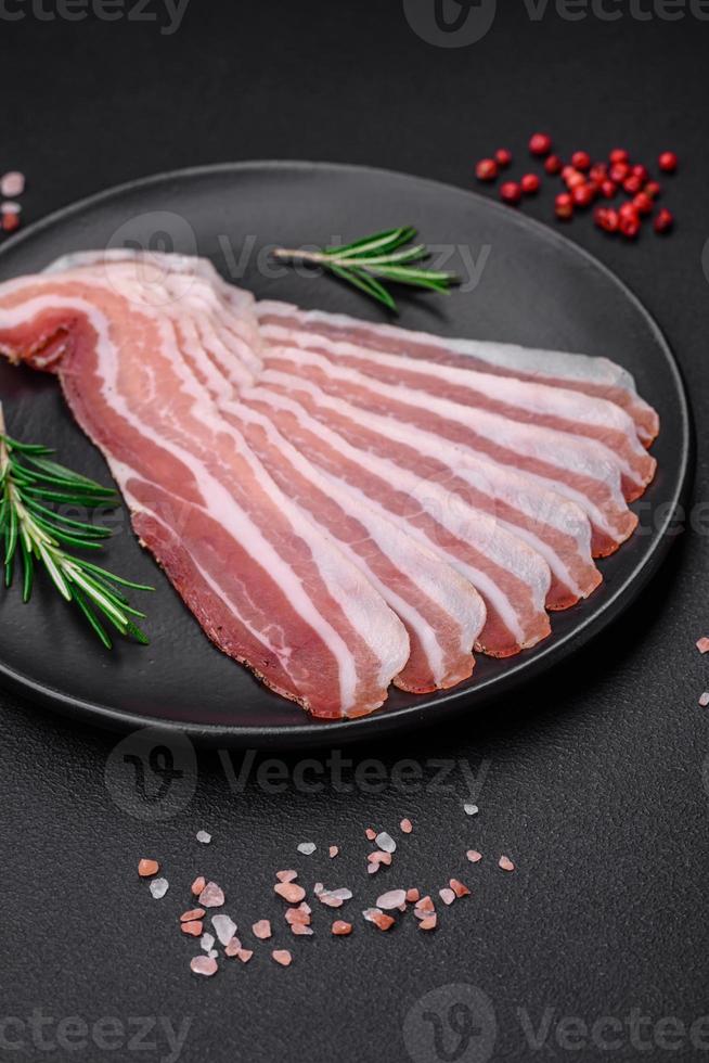 Delicious fresh pancetta with salt and spices cut into thin slices photo