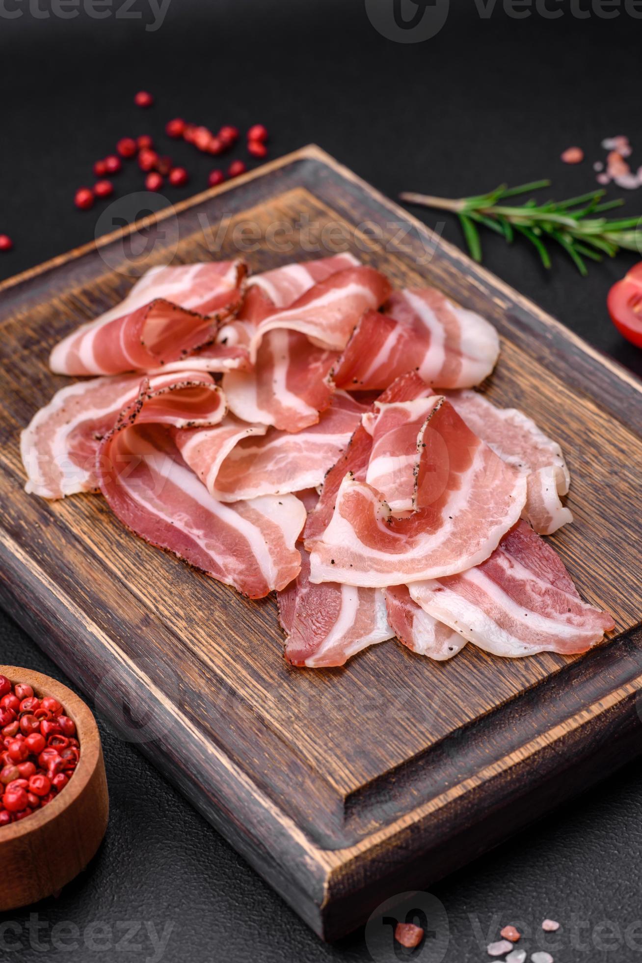 Delicious fresh pancetta with salt and spices cut into thin slices