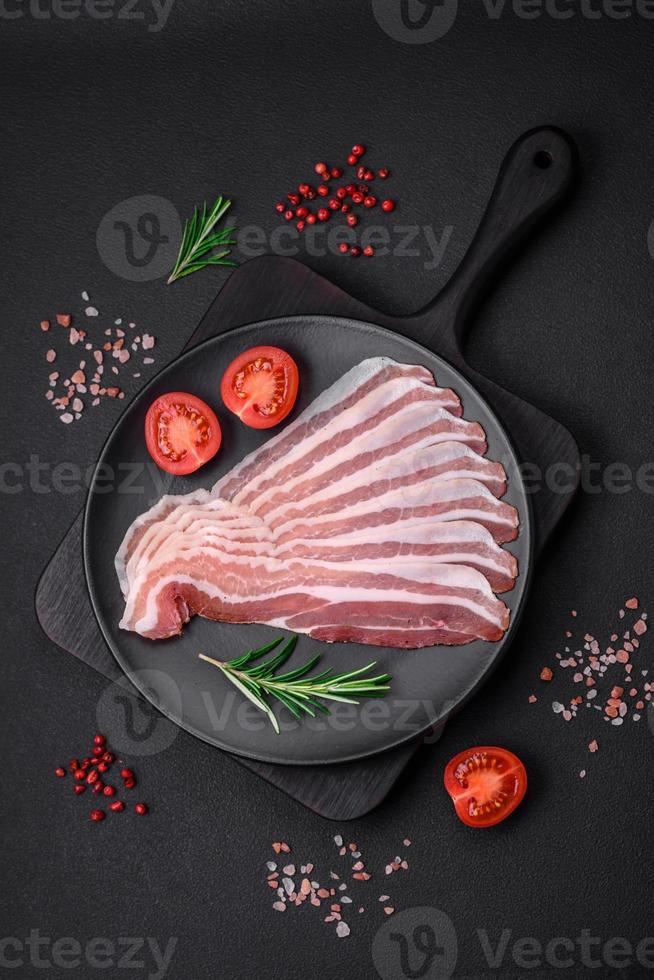 Delicious fresh pancetta with salt and spices cut into thin slices photo