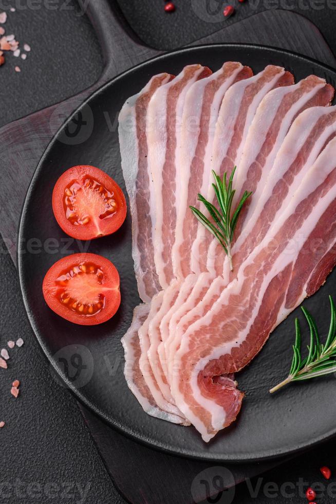 Delicious fresh pancetta with salt and spices cut into thin slices photo