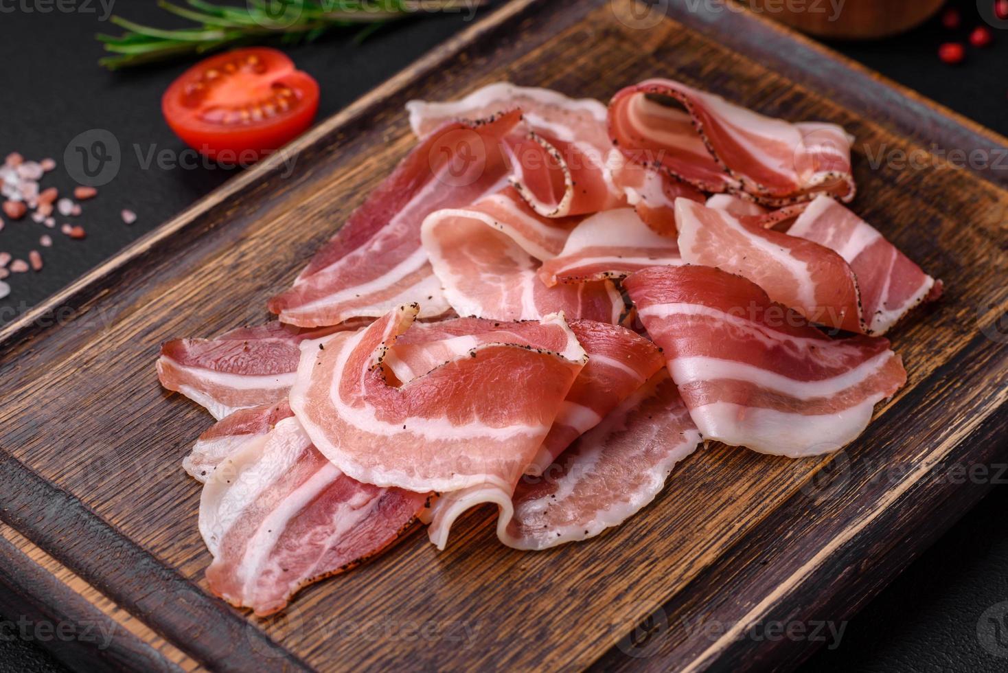 Delicious fresh pancetta with salt and spices cut into thin slices