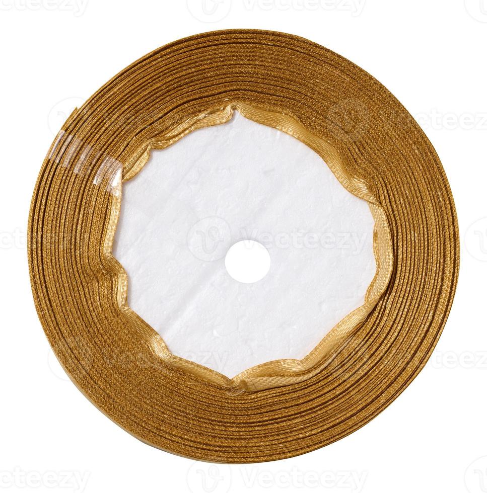 A spool with a golden silk ribbon on a white isolated background, an object for decoration photo
