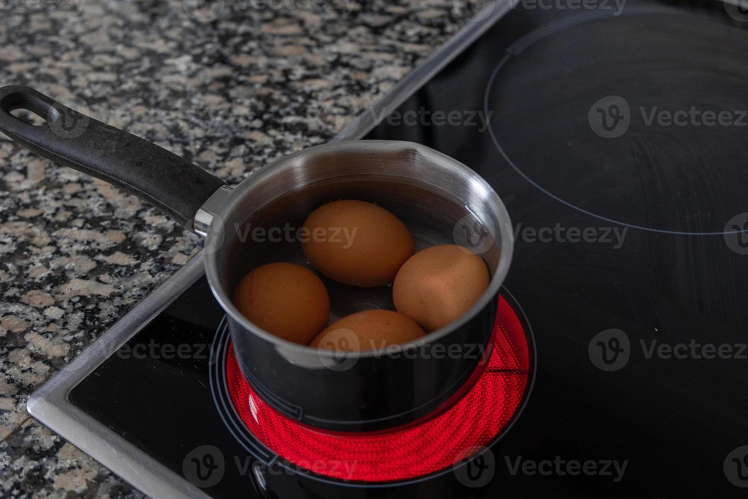 eggs in a steel aluminum pot are cooked on an electric cooker photo