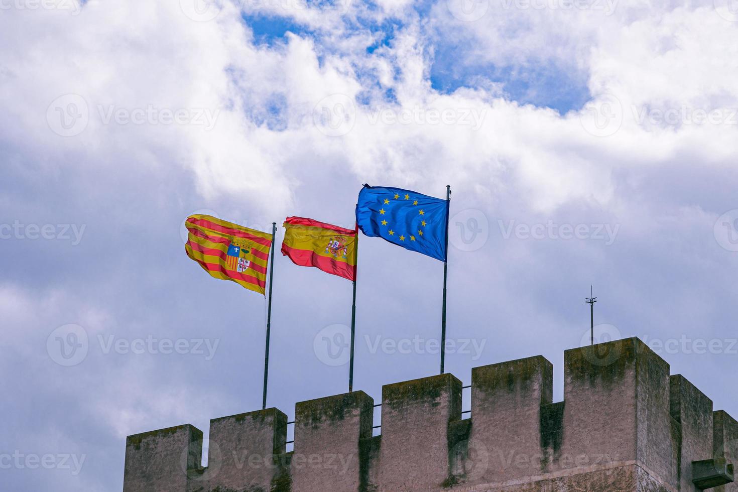 europeo Unión y Aragón España banderas en contra el cielo en un Roca histórico castillo foto