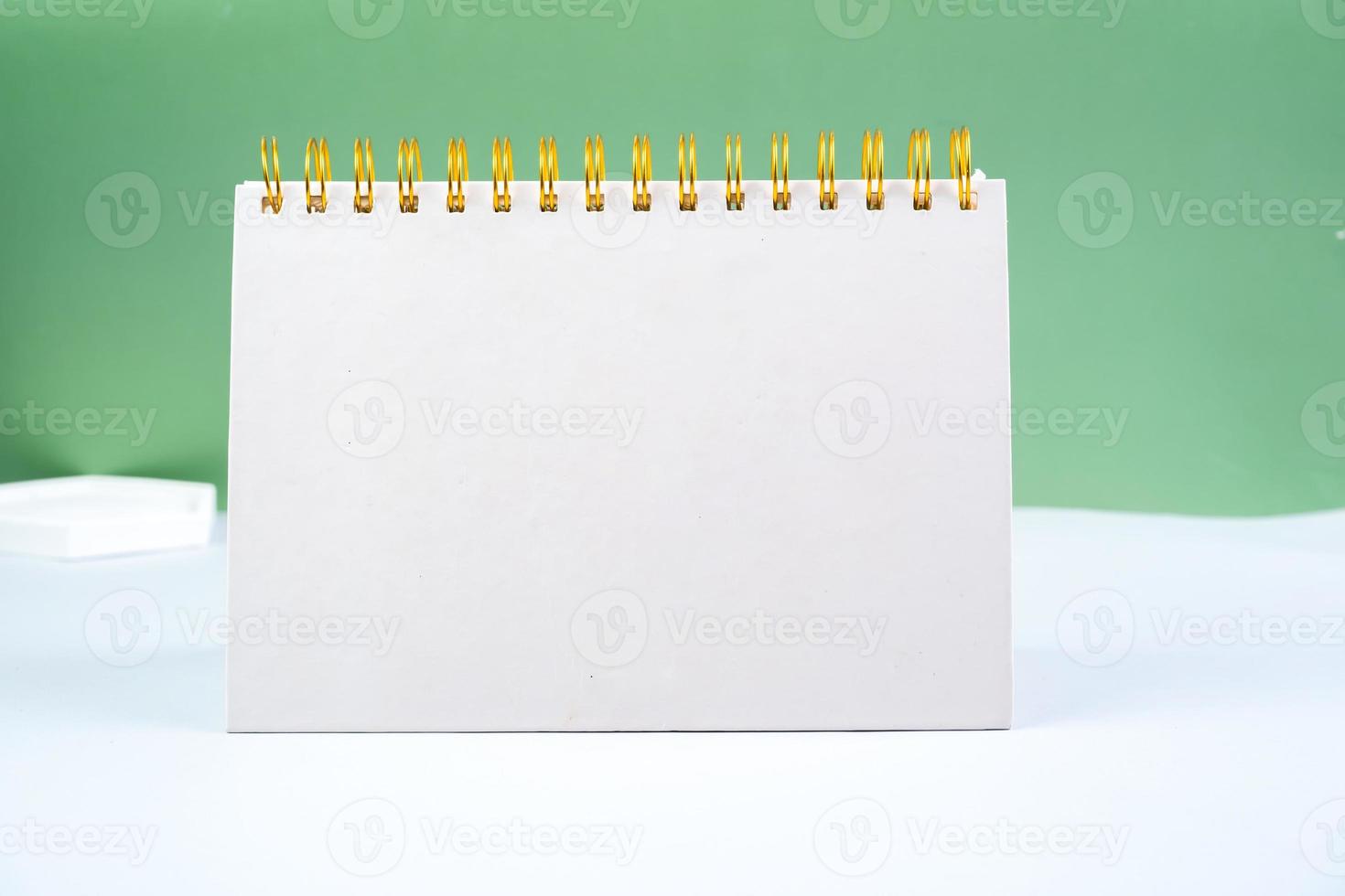 Blank white spiral notepad on a green background. notebook with space for your text, ready for your message. photo