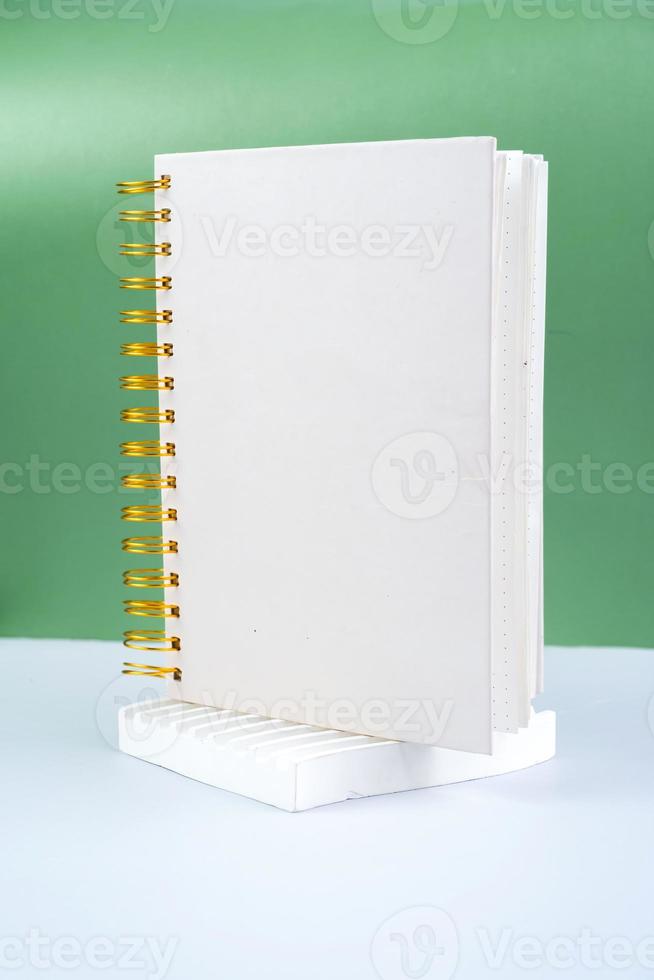 Blank white spiral notepad on a green background. notebook with space for your text, ready for your message. photo