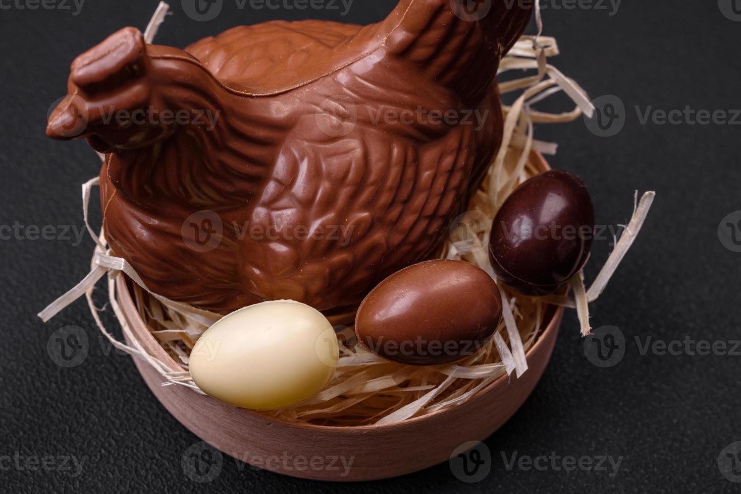 Chocolate Easter hen and eggs in a nest with straw photo