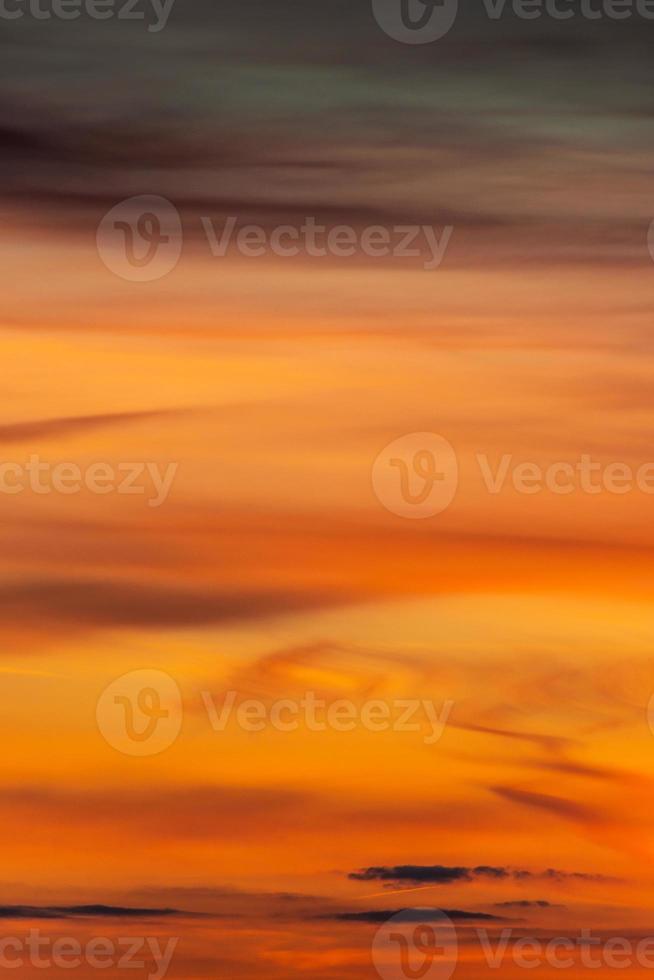 cubrir página con degradado profundo naranja cielo, iluminado nubes a sangriento puesta de sol como un antecedentes. foto