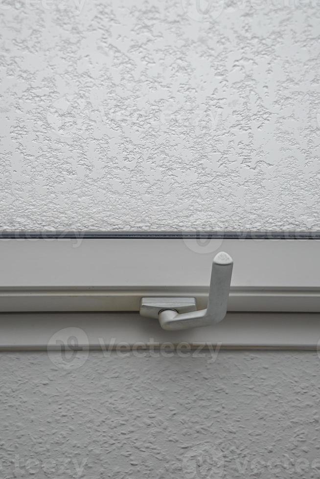 Wet and snowy with water drops and ice glass window at rainy, stormy and snowy day. Concept of seasonal mood, background with copy space. photo