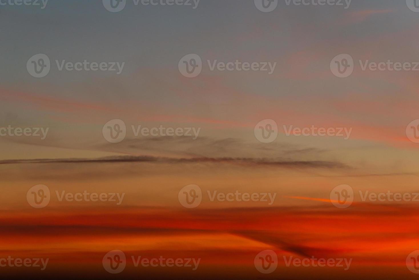 Panoramic view with gradient deep orange sky, illuminated clouds at bloody sunset as a background. photo