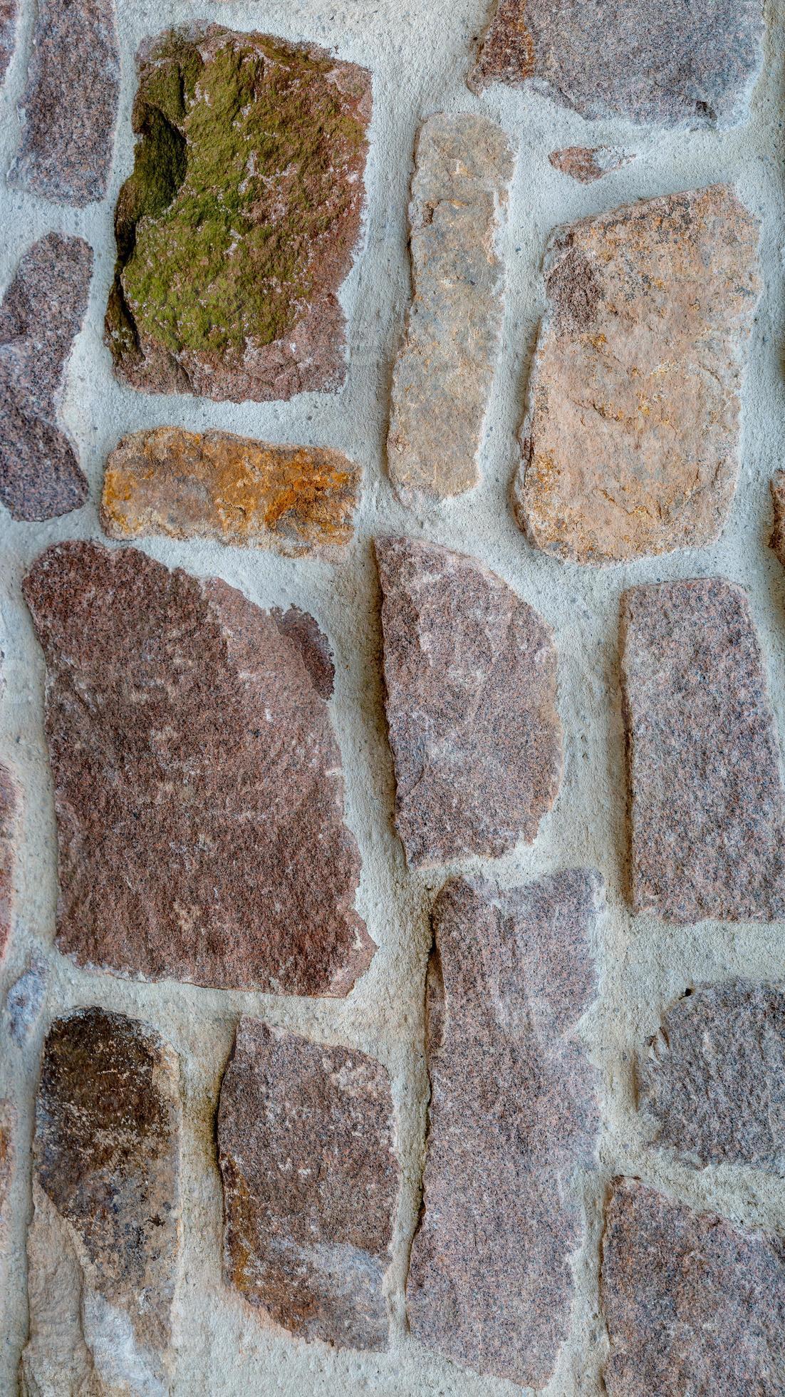 Panoramic view over a long middle age stone wall with patterns of