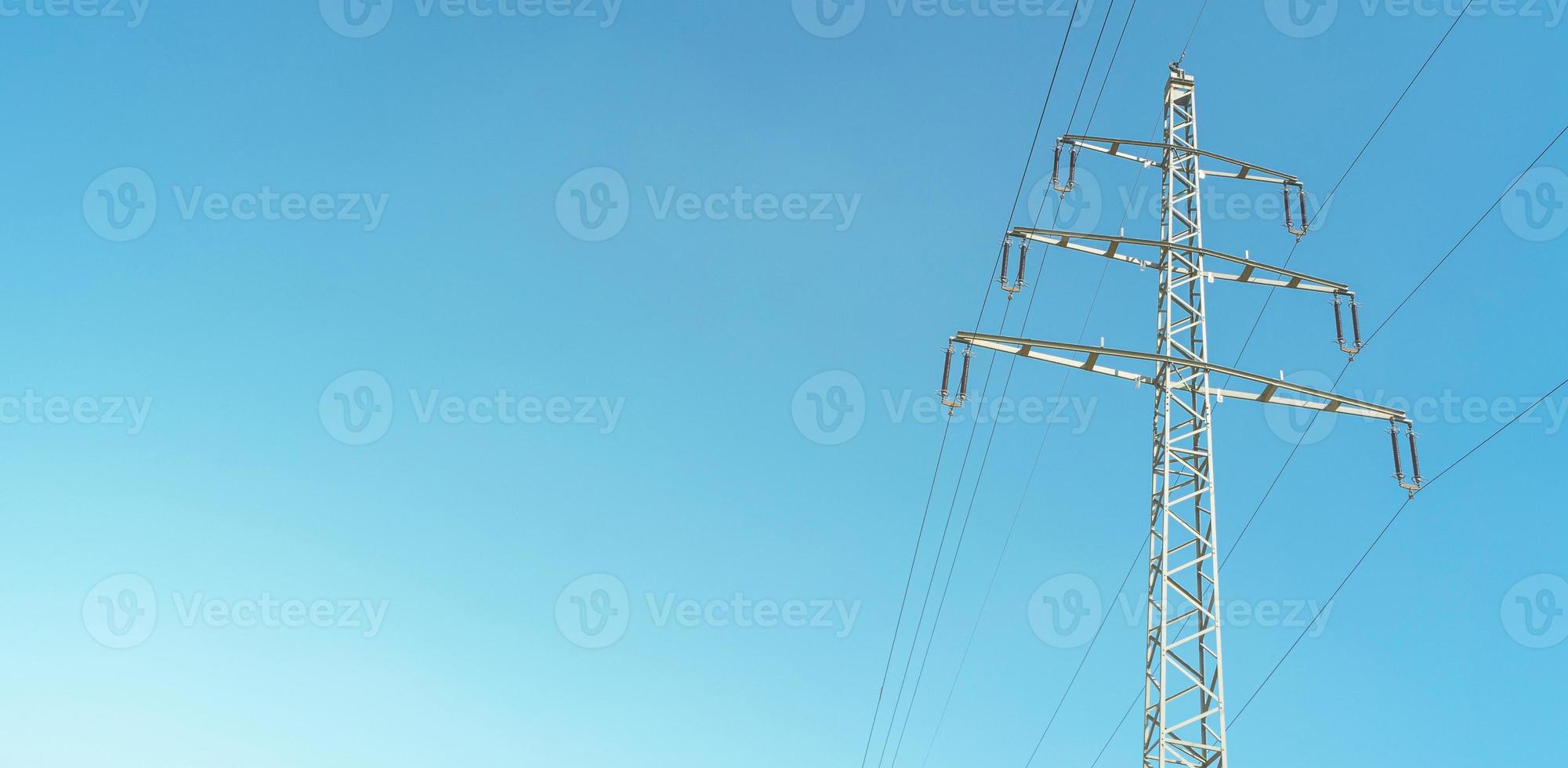 Modern high voltage electrical power line pylon and wire lines in Germany, in the blue gradient sunset sky and sunset colors and copy space. Concept of energy supply and energy crisis photo