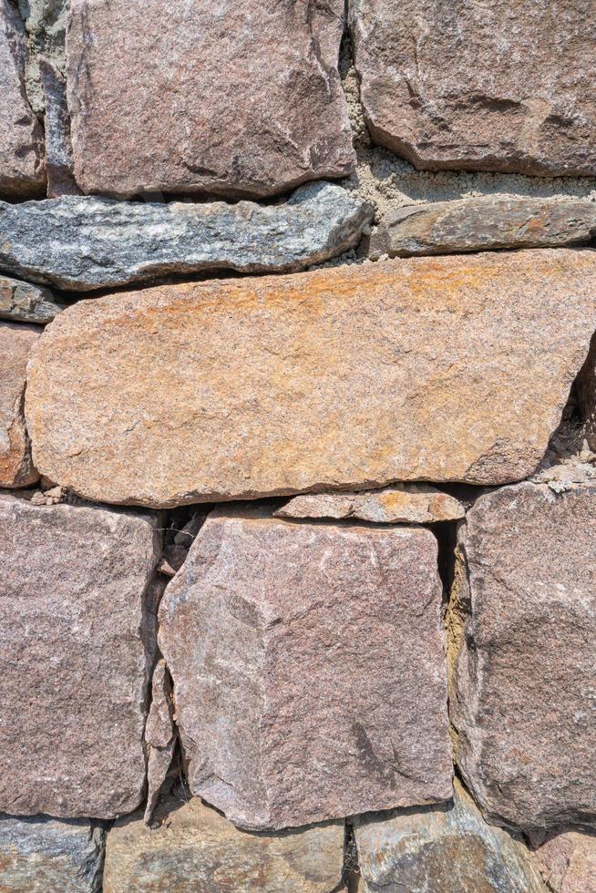 Pattern of ancient bricks and stones at old middle age fortress wall, as a background, closeup, details. photo