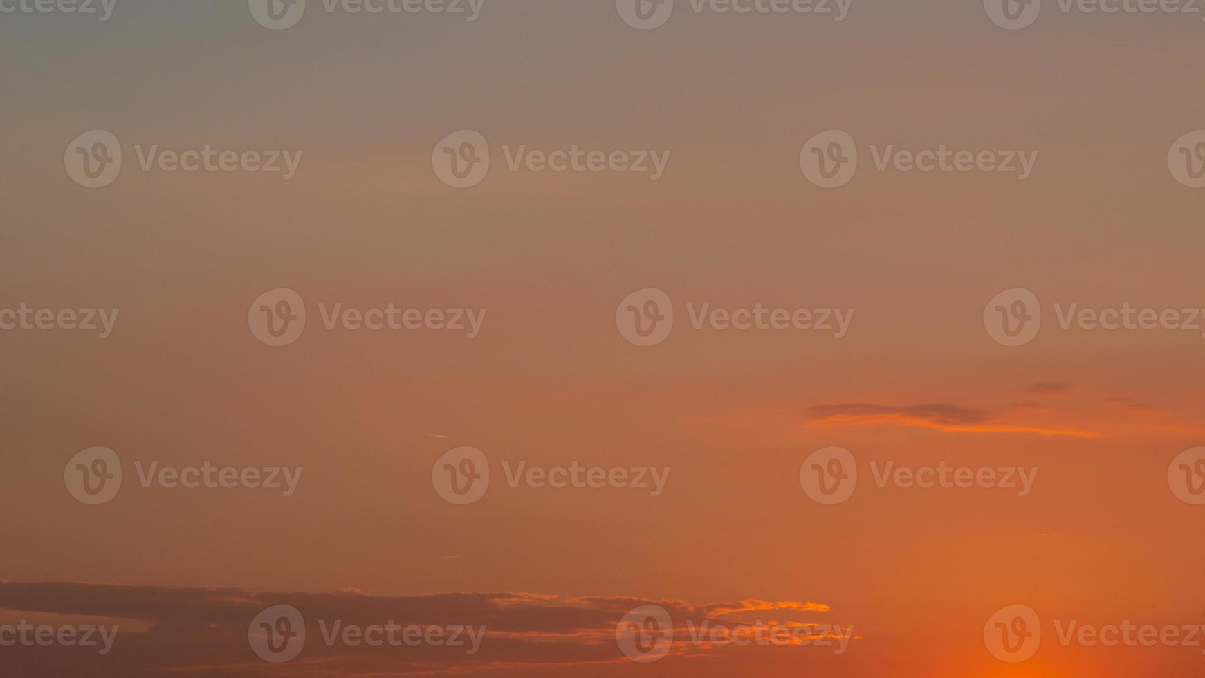 Soft deep orange sky, illuminated clouds at bloody sunset as a background. photo