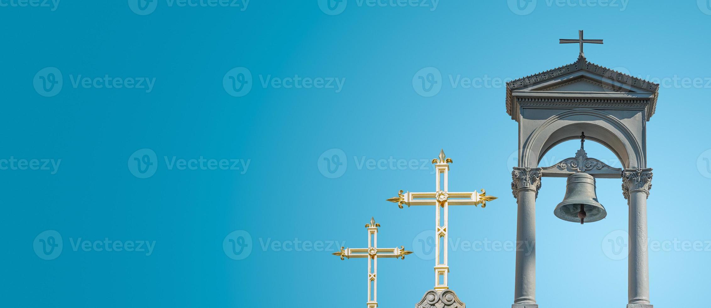 Banner with ancient monastery poor bell tower with rich golden crosses at blue sky gradient background with copy space. Concept of religious contrast, inequality. photo