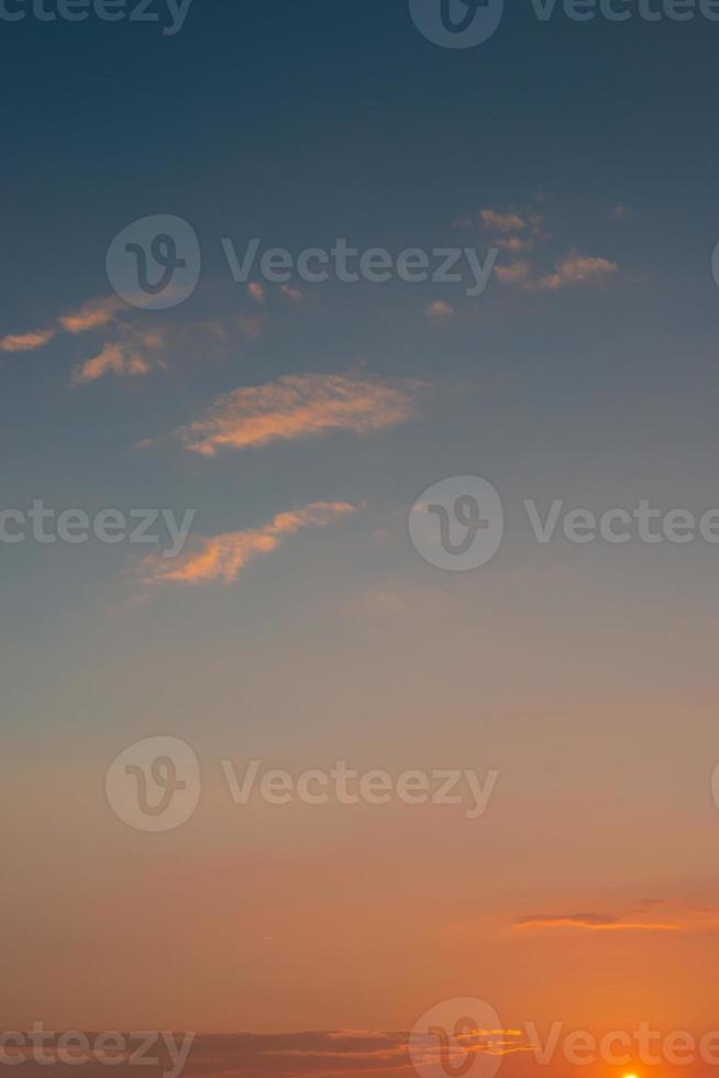 cubrir página con degradado suave profundo naranja cielo, iluminado nubes a sangriento puesta de sol como un antecedentes. foto