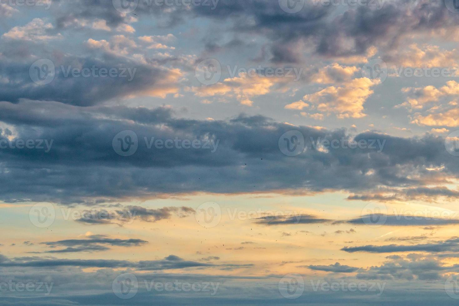 Soft deep orange sky, illuminated clouds at bloody sunset as a background. photo