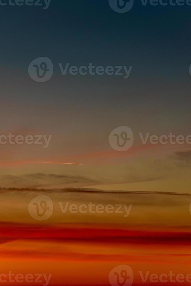 Cover page with gradient deep orange sky, illuminated clouds at bloody sunset as a background. photo
