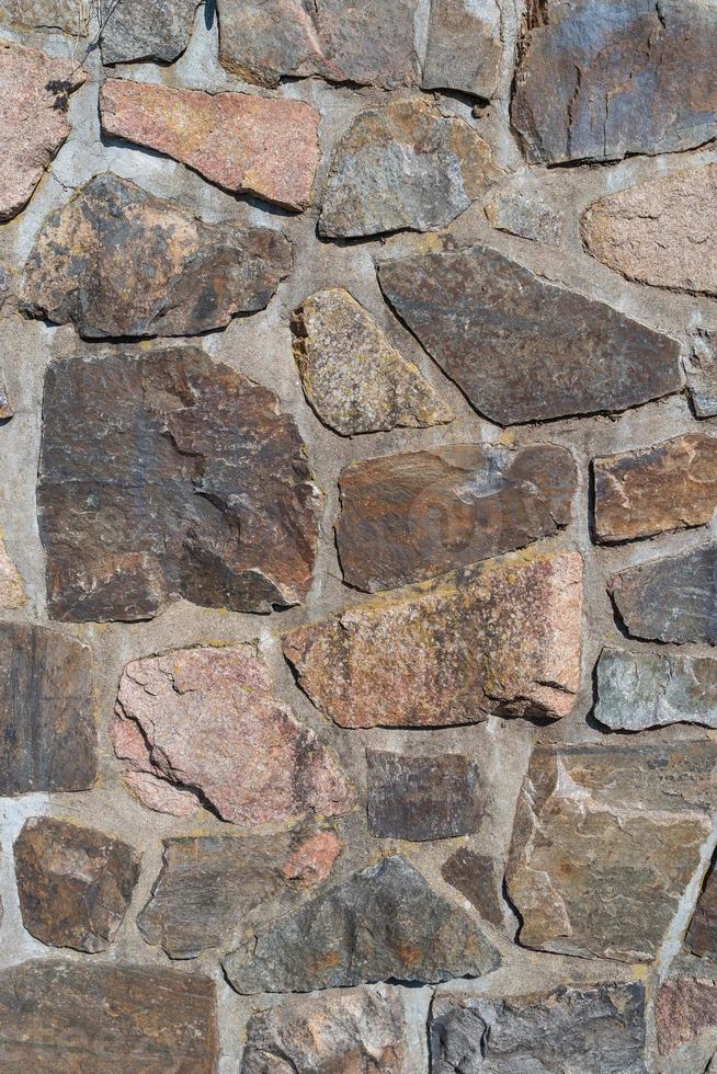 Pattern of ancient bricks and stones at old middle age wall, as a background, closeup, details. photo