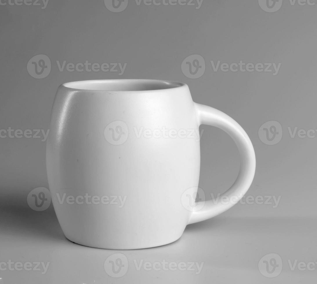 White cup on a gray background. Side view. photo