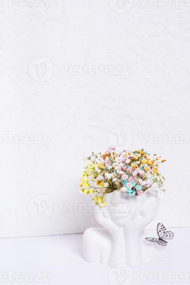 mental salud concepto. creativo florero forma de la cabeza con vistoso flores y mariposa en blanco antecedentes foto