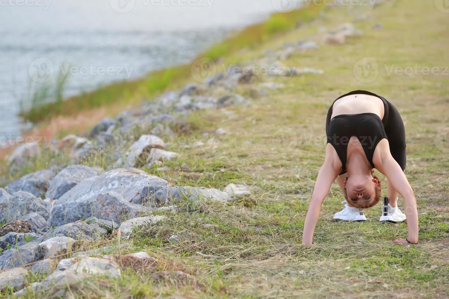 Young girl doing yoga fitness exercise Morning sunrise outdoor in  the meadow beautiful mountains landscape. Meditation and Relax. photo