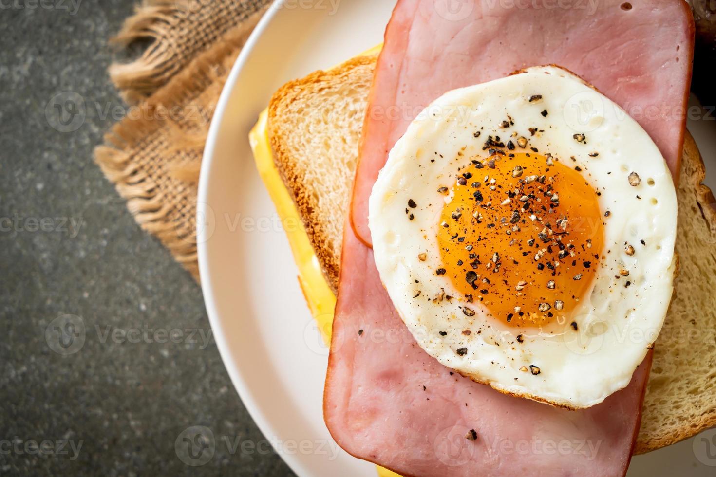 bread toasted cheese topped ham and fried egg with pork sausage photo