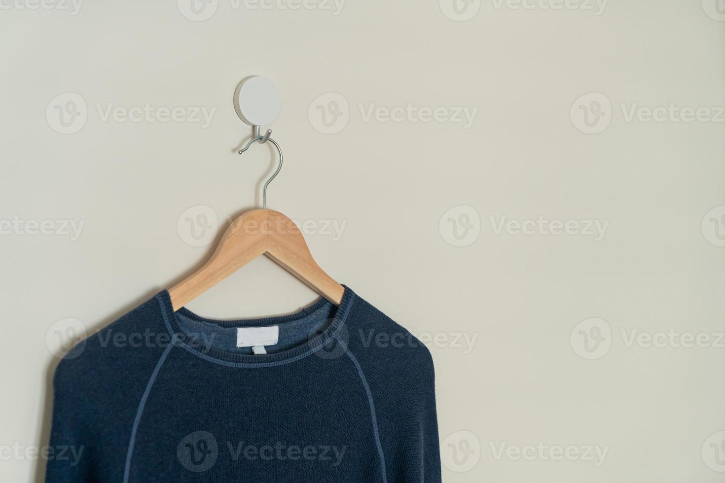 navy sweater hanging with wood hanger photo