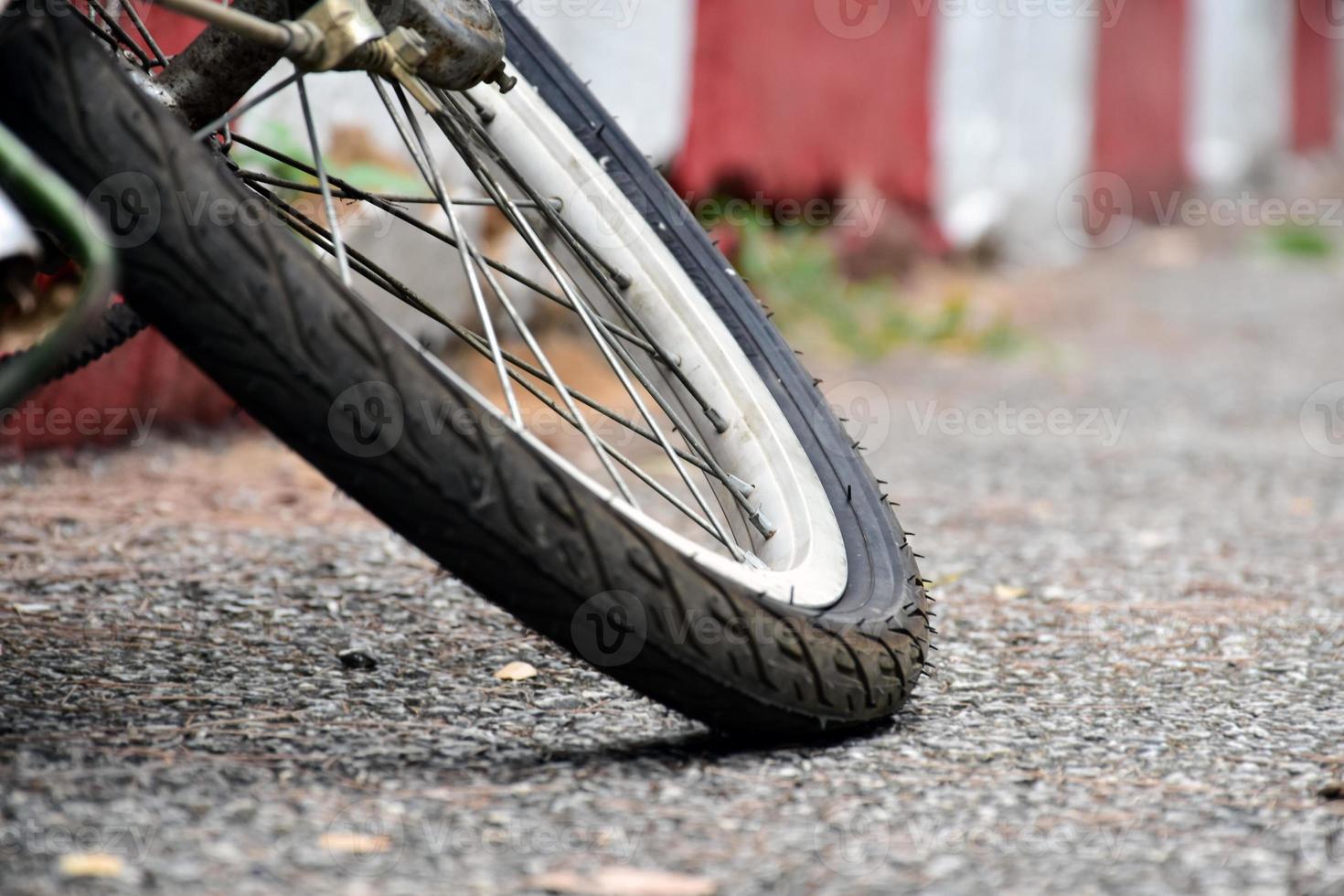 Bike flat tires which parked on red-white line beside the road in the public park, soft and selective focus on tire. photo