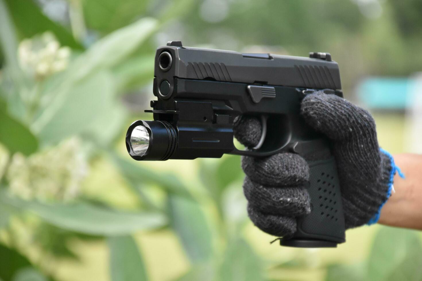 semi automatic 9mm pistol gun and bullets on wooden background, concept for training and practising gun shooter to protect human life and properties around the world. photo