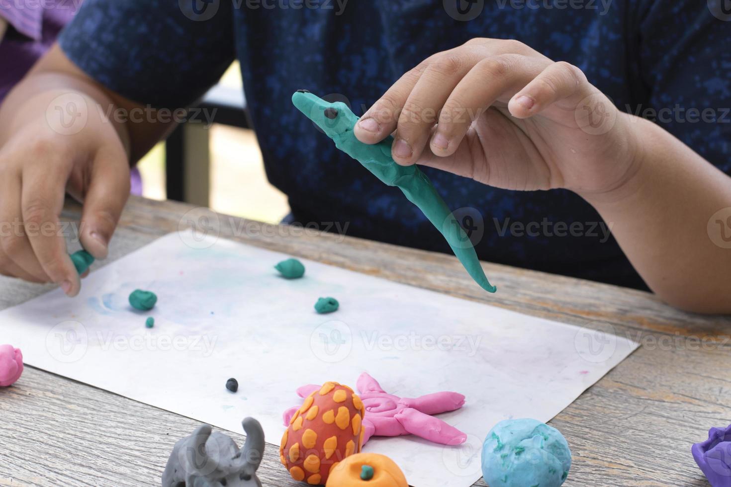 An autistic boy molding different shapes of colored plasticine prepared by parents at home in order to develop various aspects in their son which has slower brain development than normal children. photo