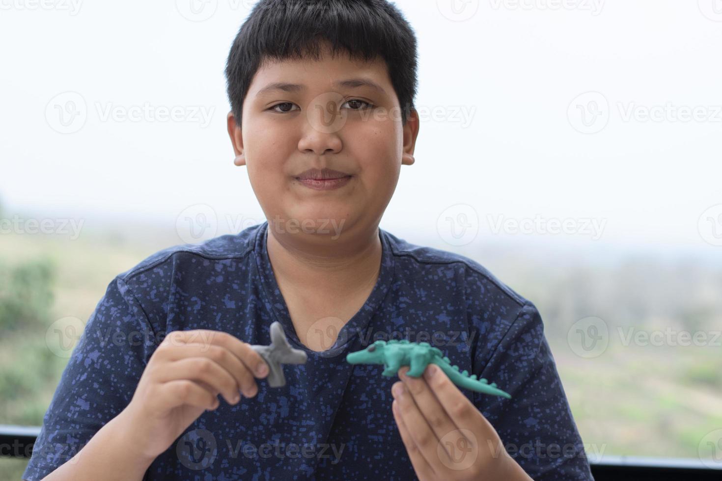 An autistic boy molding different shapes of colored plasticine prepared by parents at home in order to develop various aspects in their son which has slower brain development than normal children. photo