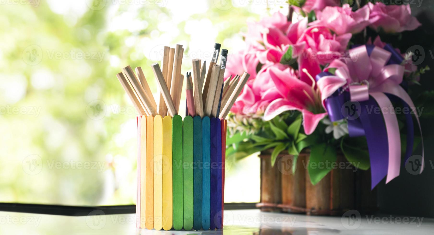 Closeup view of rainbow case which has various pencils inside, blurred nature ouside window background, concept for LGBT celebration in pride month and home decoration of LGBT people around the world. photo