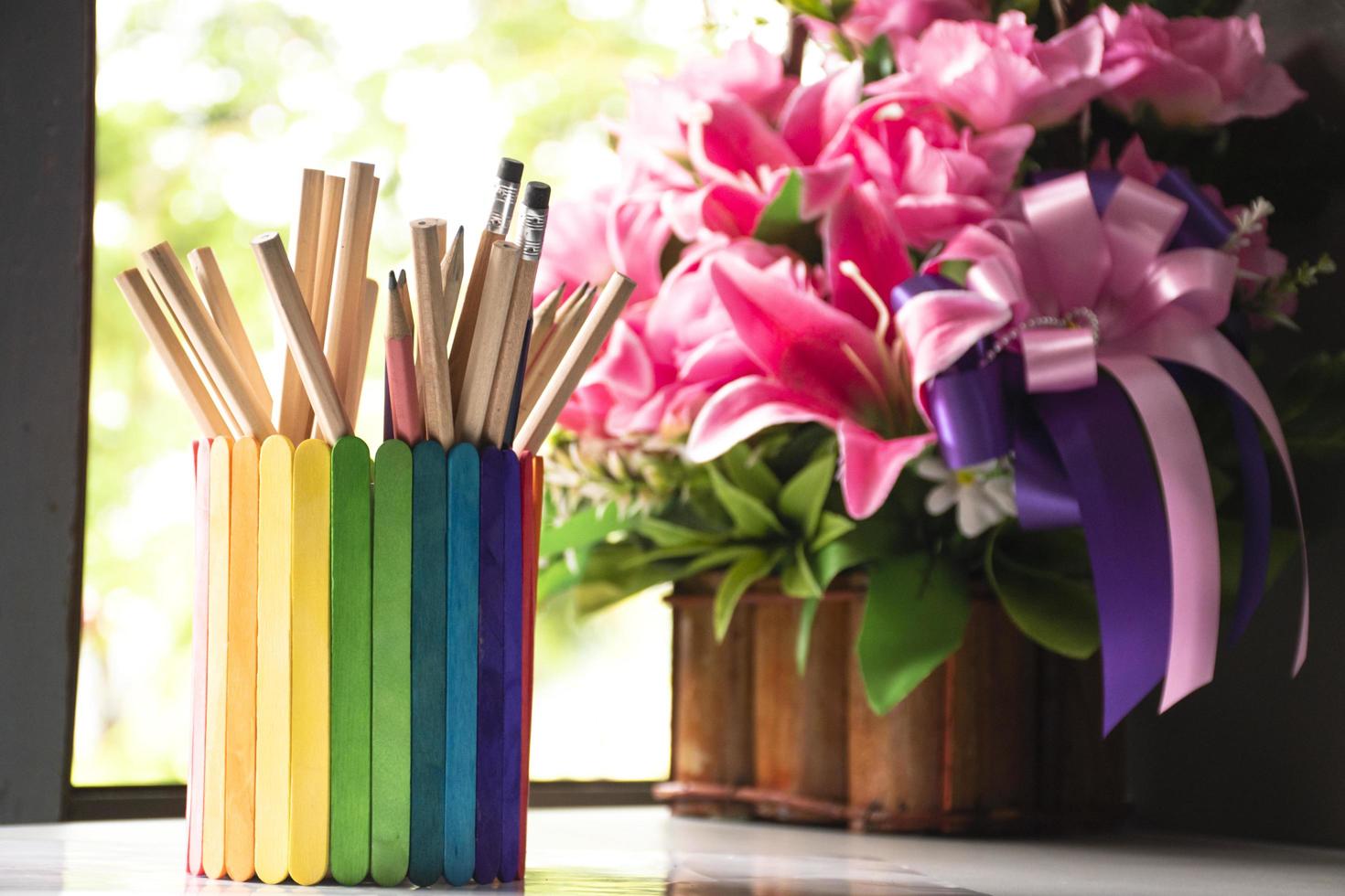 Closeup view of rainbow case which has various pencils inside, blurred nature ouside window background, concept for LGBT celebration in pride month and home decoration of LGBT people around the world. photo