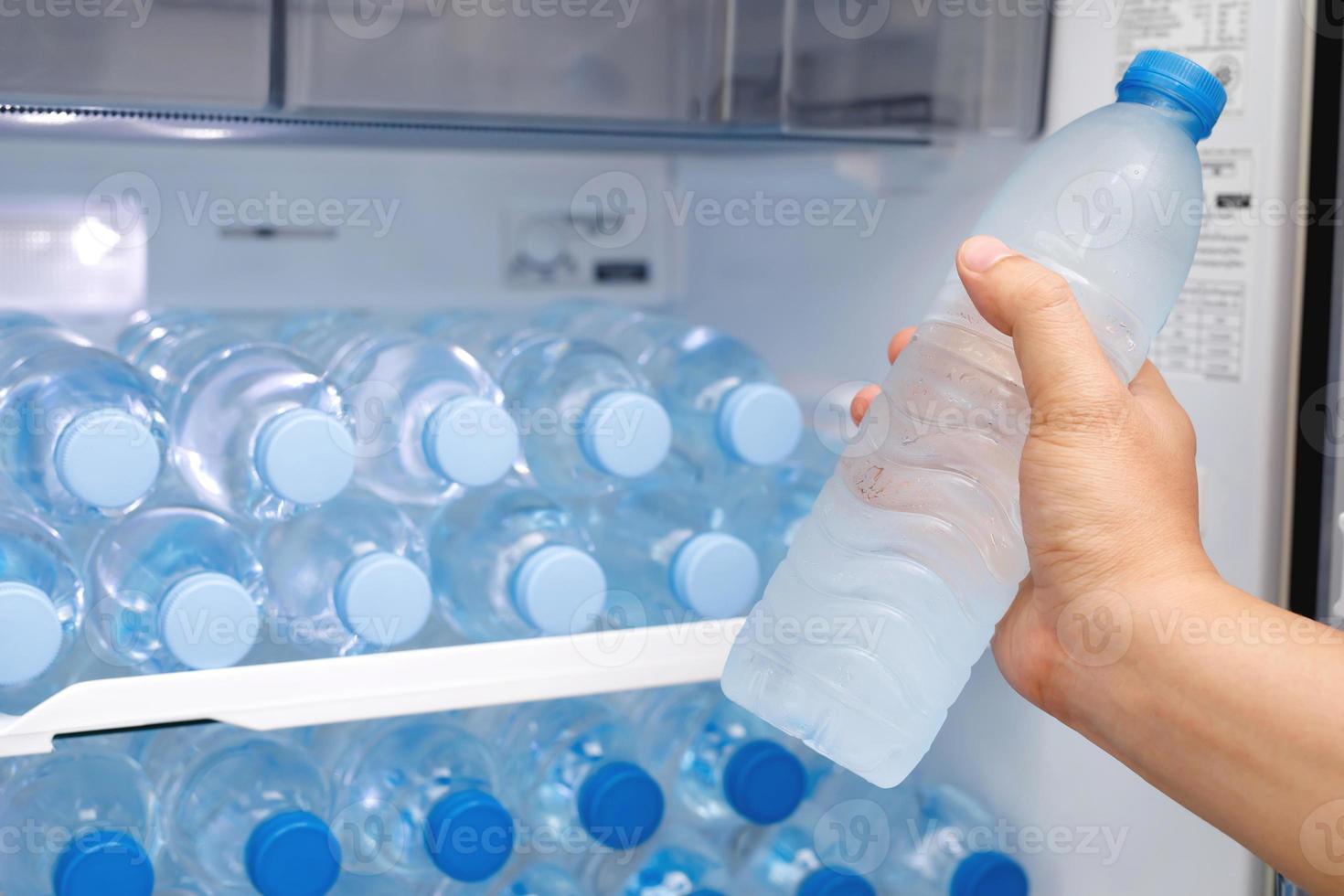 frío Bebiendo agua en el refrigerador foto