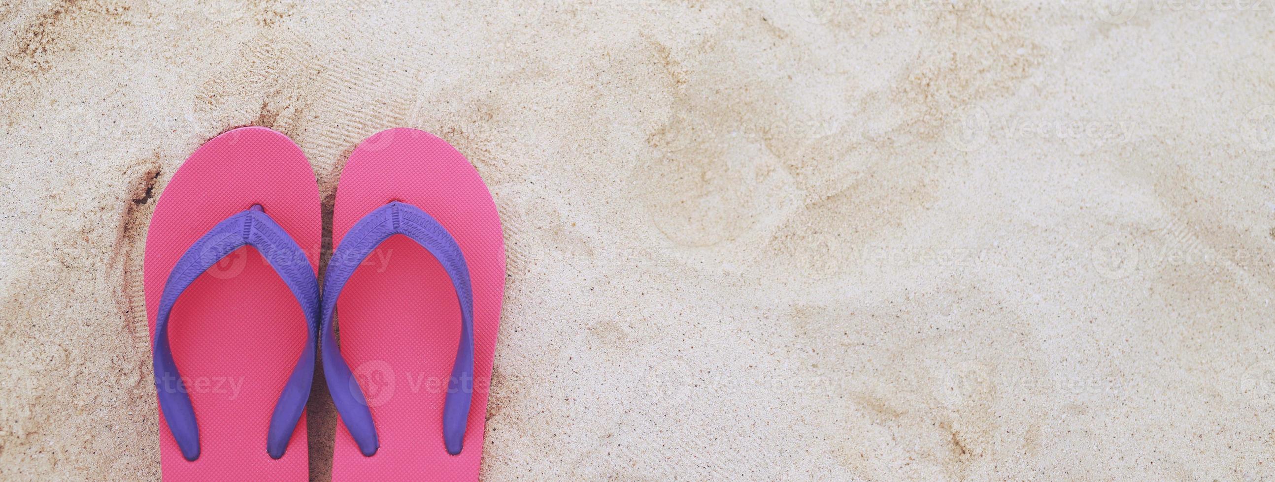 sea on the beach Footprint  people on the sand and slipper of feet in sandals shoes on beach sands background. travel holidays concept. photo