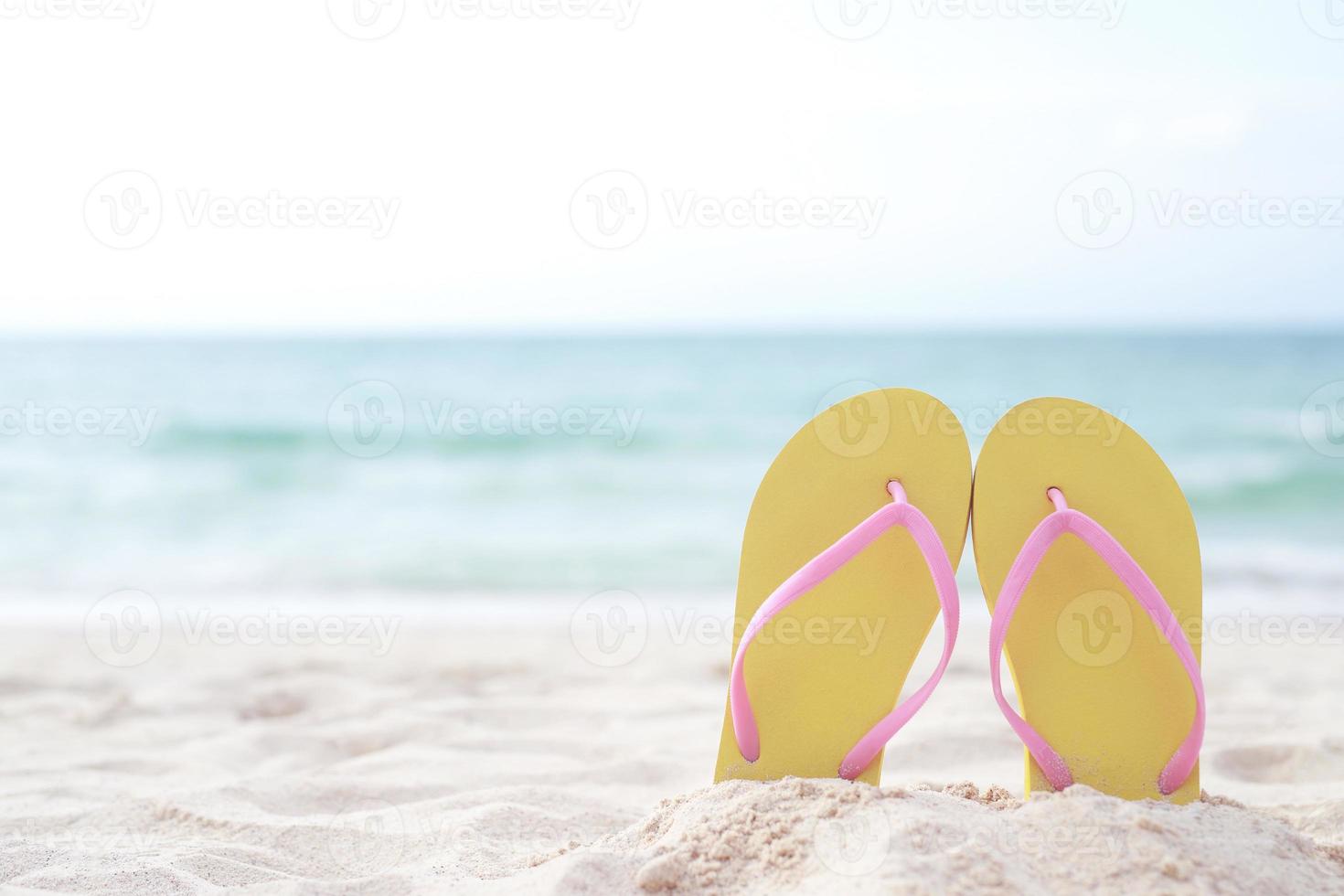 sea on the beach Footprint  people on the sand and slipper of feet in sandals shoes on beach sands background. travel holidays concept. photo