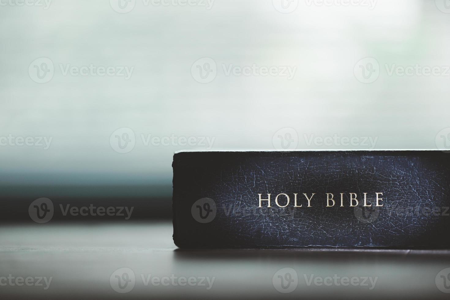 Holy bible book for education on wooden table with background. Christian catholic with protestant worship and pray in church. Concept of learning about faith god and religion, jesus spiritual. photo