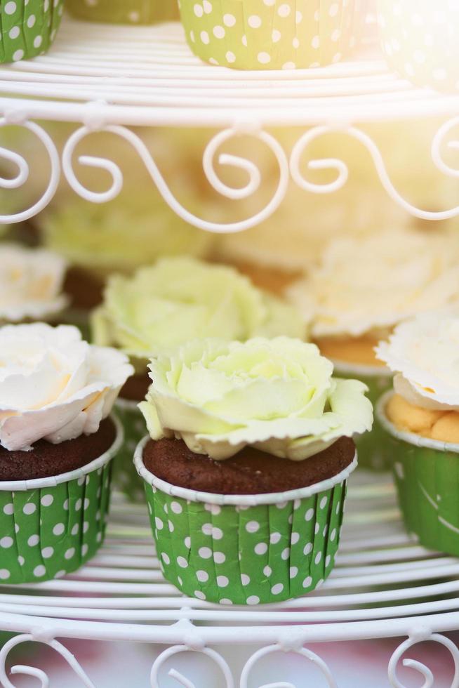 Wedding chocolate Cupcakes in green cup with garland lights bokeh and sunlight background photo