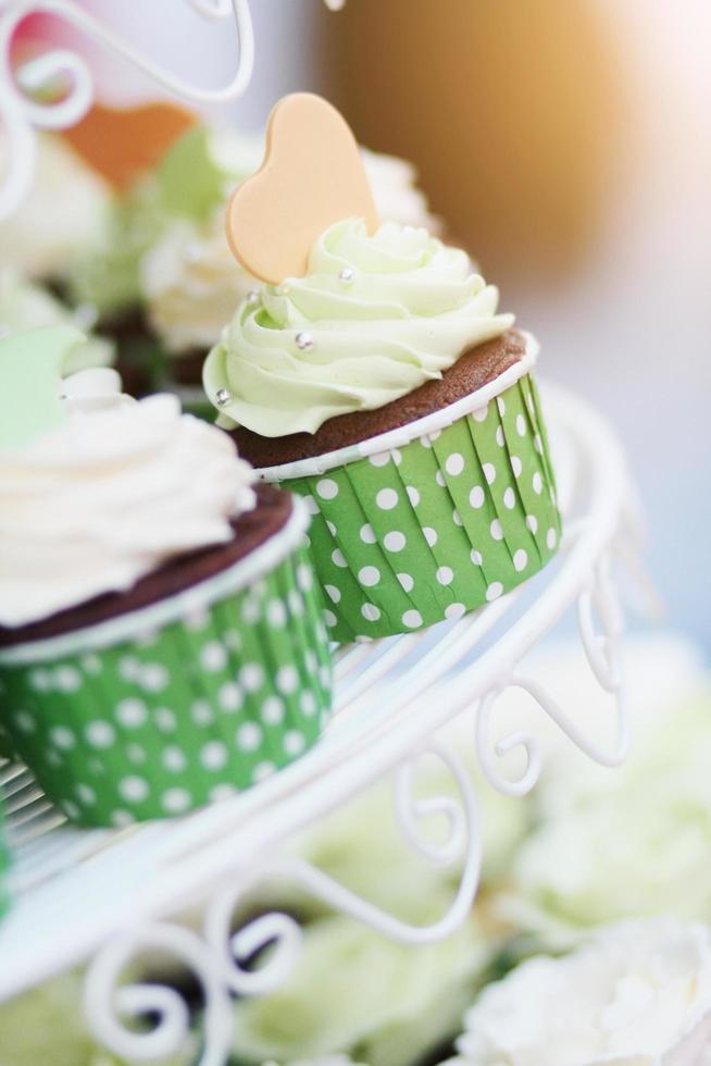 Boda chocolate magdalenas en verde taza con guirnalda luces bokeh y luz de sol antecedentes foto