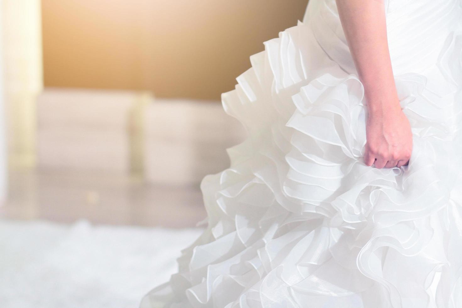 Close-up bride holding wedding dress for the wedding ceremony. photo