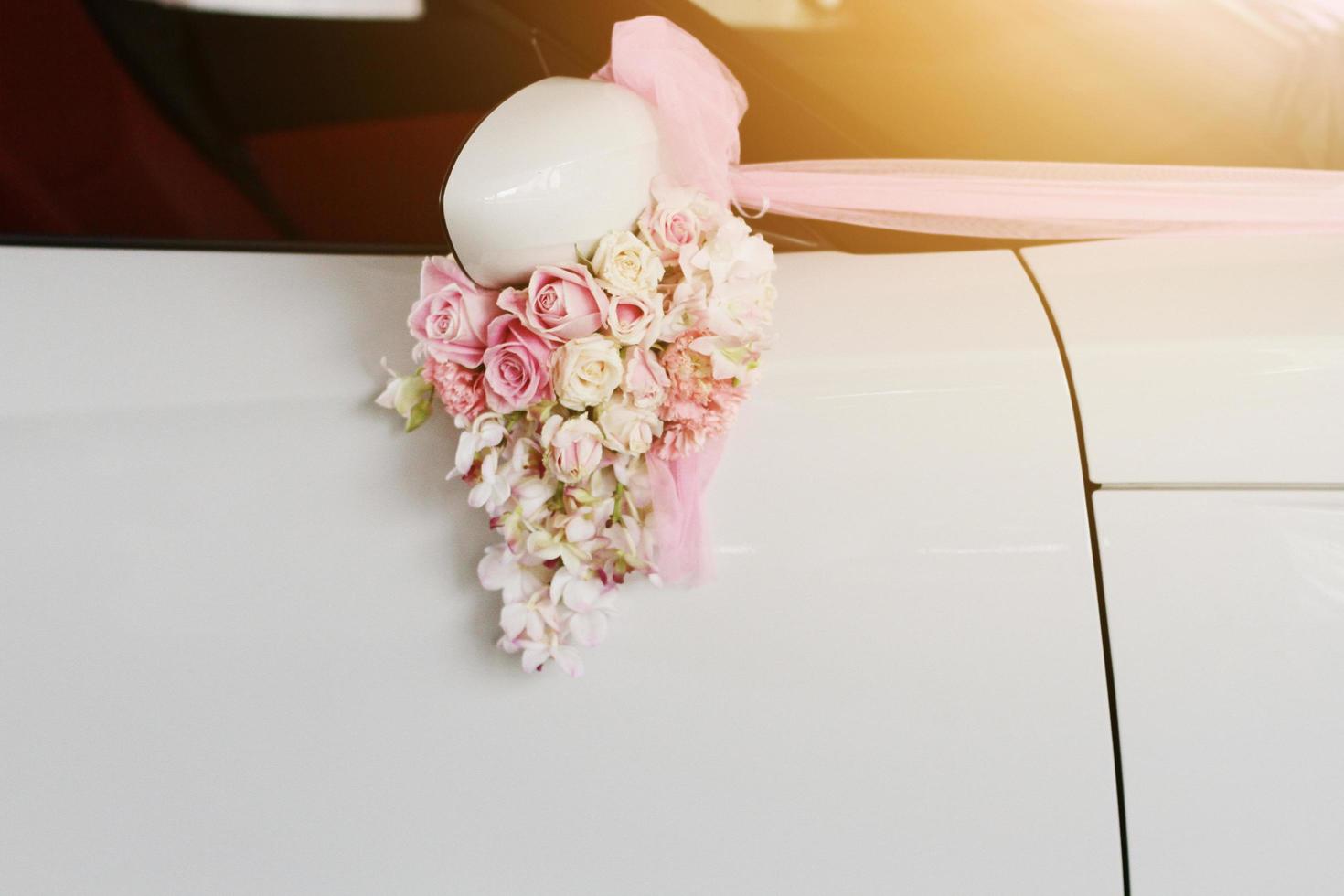 Beautiful Pink roses flower Ribbon decorated on white car door handles for wedding photo